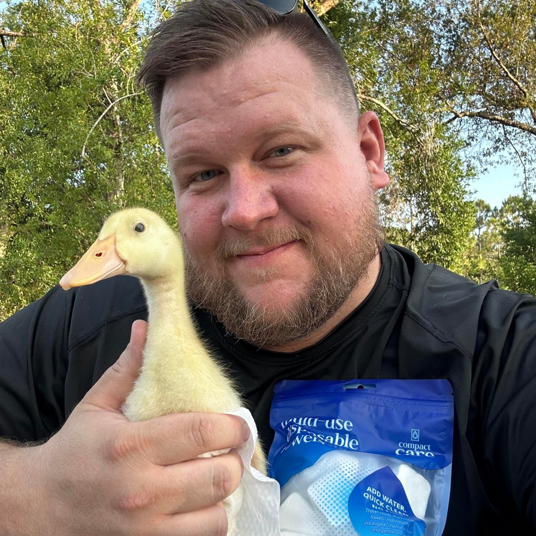 Aaron, Compact Care founder, holding a duckling and a pack of Compact Care towels